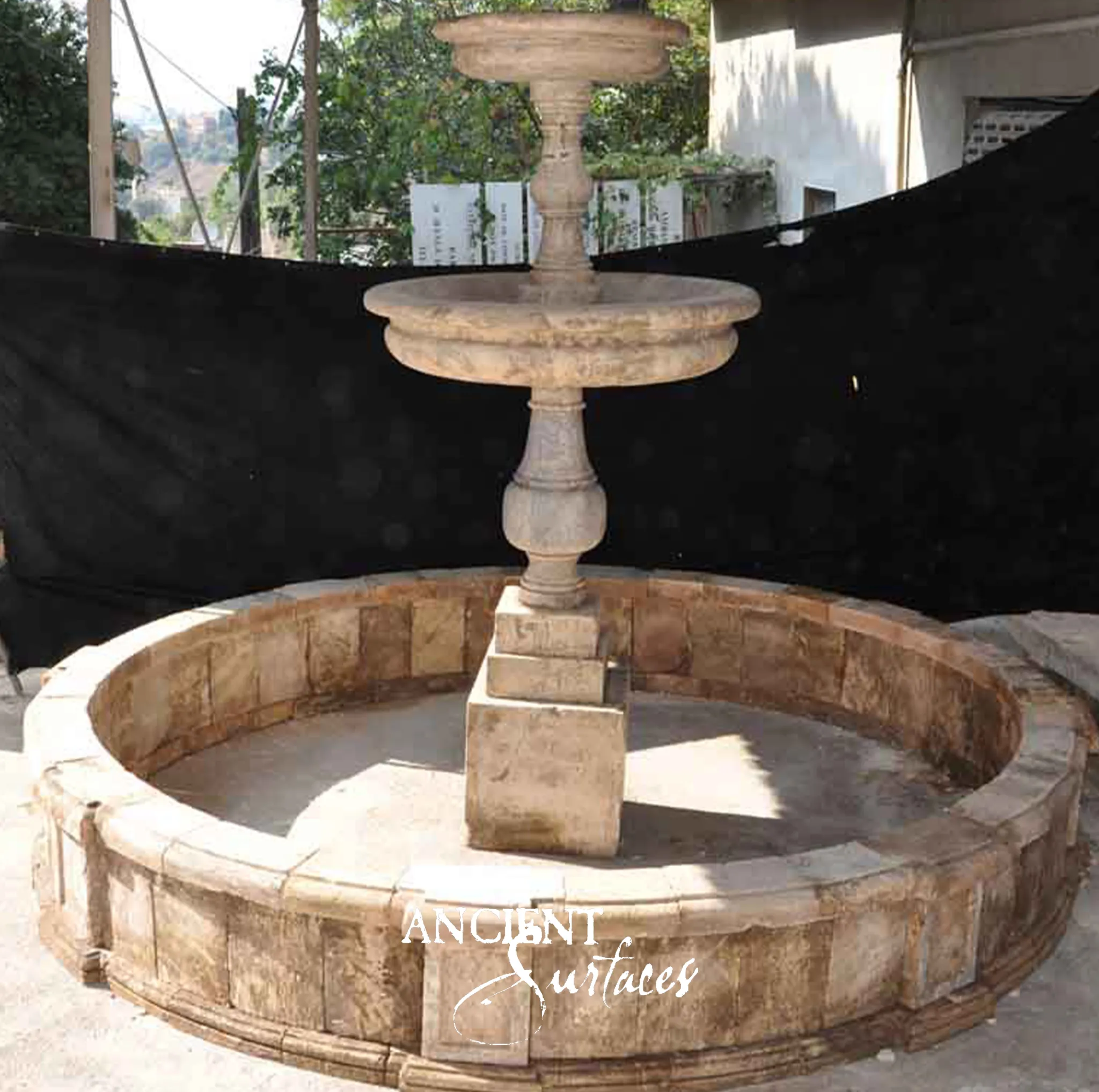 Reclaimed two tier limestone fountain from Ancient Surfaces with turned dishes on a baluster stem inside a wide circular basin